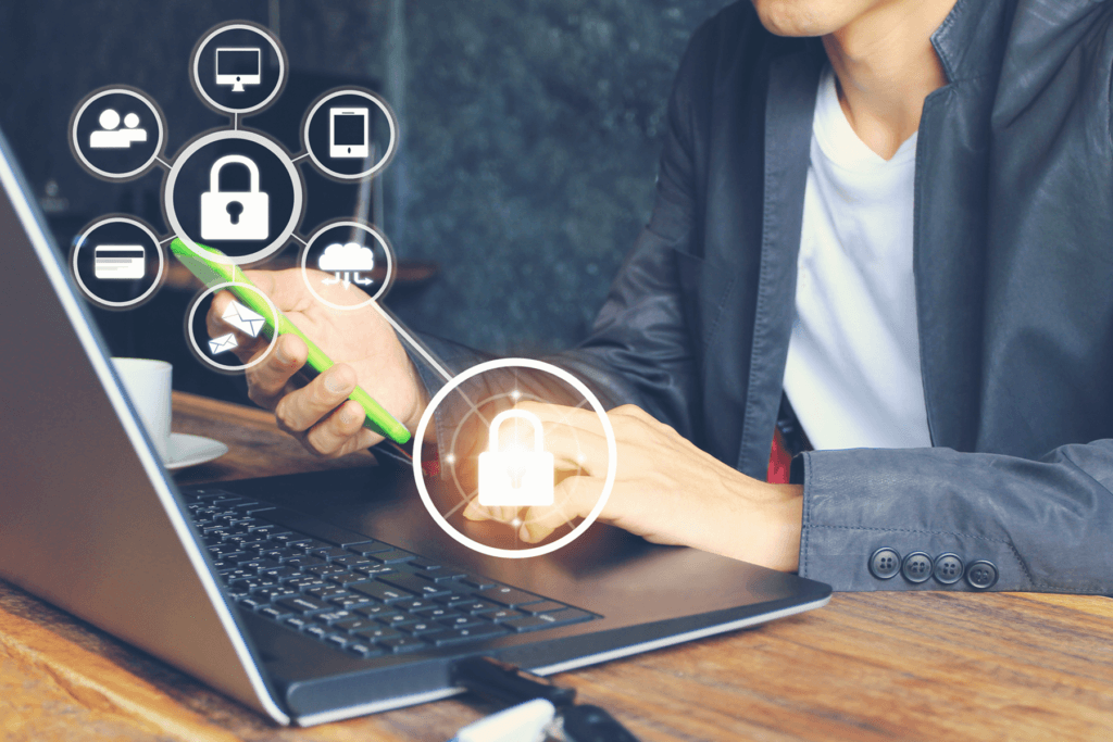 A person holds their phone while using their computer and a visualization of secure data points appear to depict their learning about Cybersecurity Awareness Month