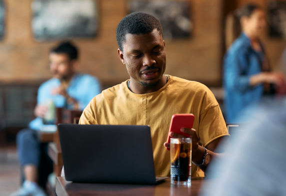 Man looking at phone in cafe
